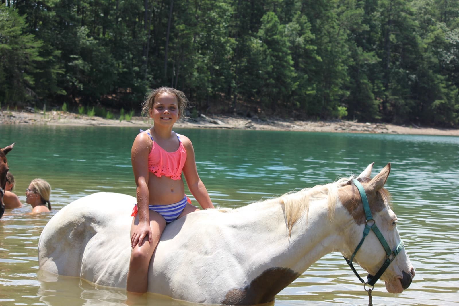 Sadie riding bareback through the lake